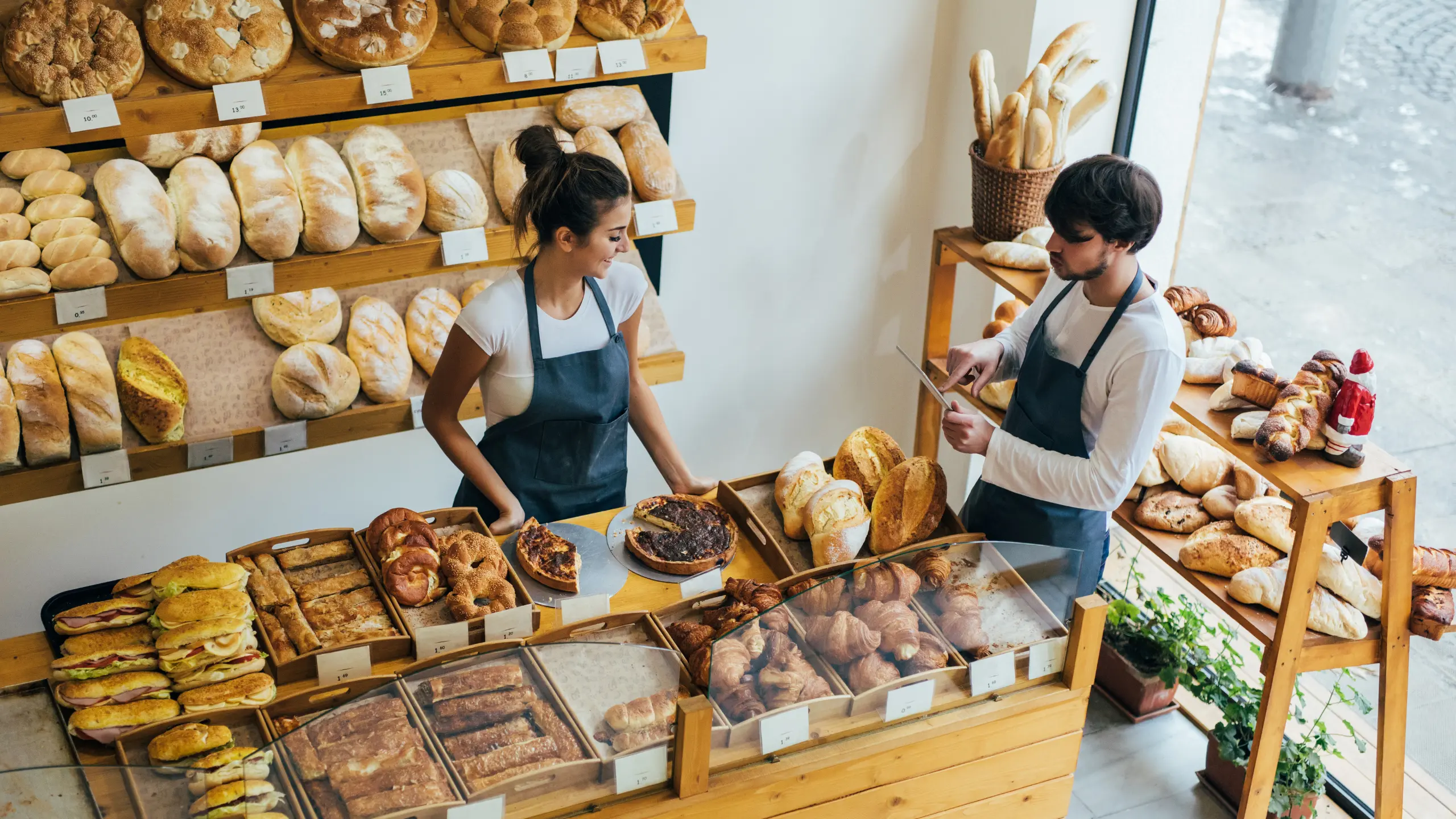 boulangerie-la-mie-de-reve deux vendeurs dans une boulangerie qui se prépare a accueillir du publique